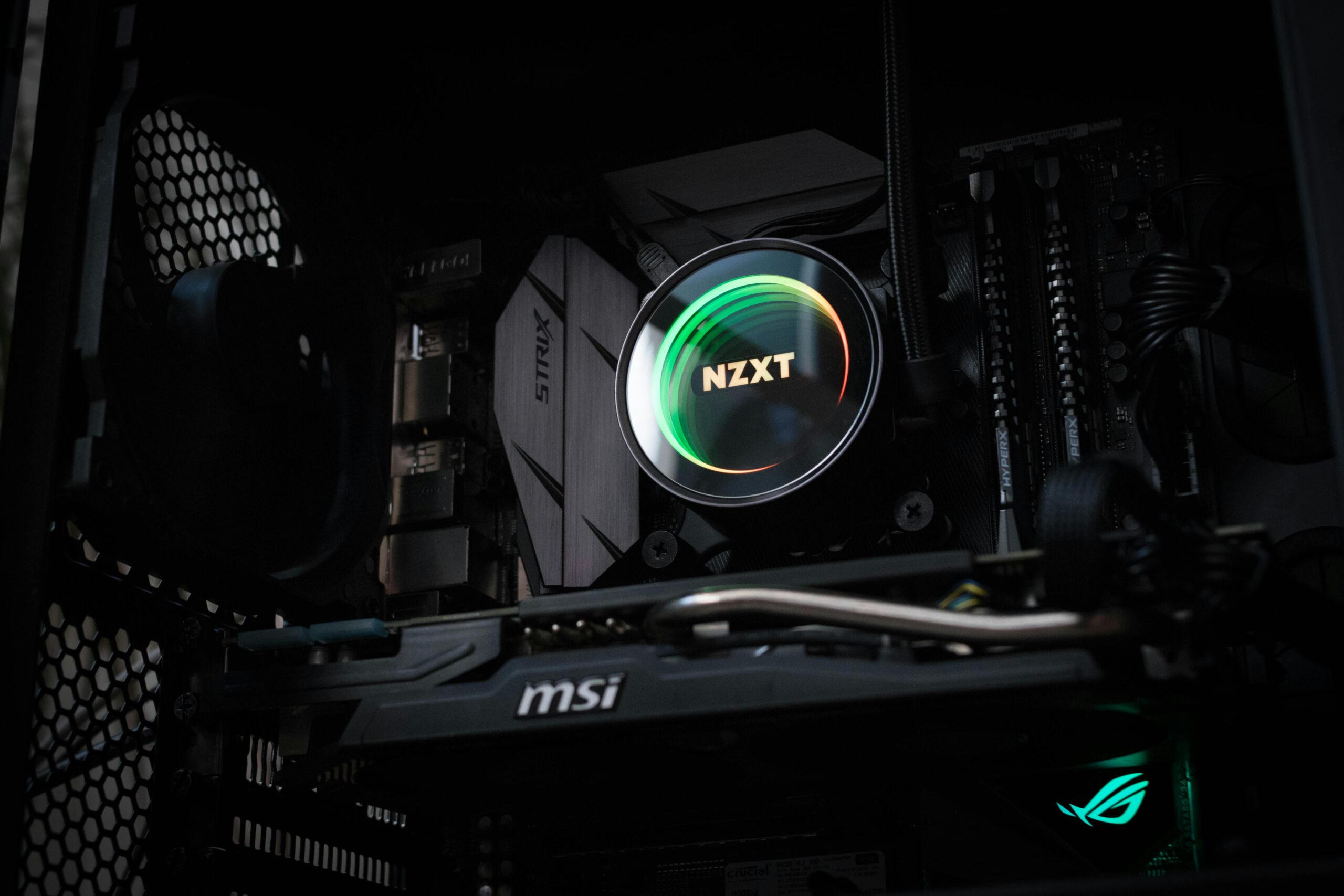 Detailed view of an illuminated NZXT cooler inside a gaming PC showcasing advanced components.